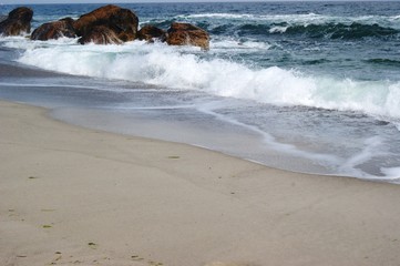 The sea, the blue aod, the waves are rooted about the stones. Summer, beach