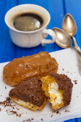 chocolate eclairs on white dish on wooden background