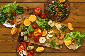 Wooden table served with cut fruits and vegetables