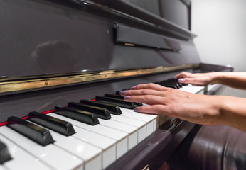 Obraz premium Young woman hands playing on piano (shallow DOF)
