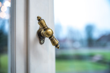 Retro Bronze Handle on a White Aged Wooden Window