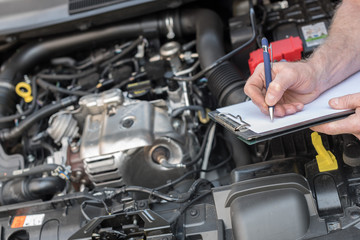 Car mechanic checking a car engine - obrazy, fototapety, plakaty