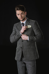young businessman with dollar banknotes in pocket isolated on black