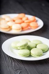 Green and orange colored French macaroons or macarons