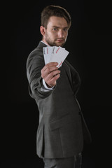 side view of businessman showing Joker cards isolated on black
