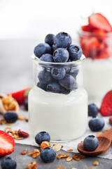 Delicious plain yogurt with fresh blueberry and strawberry in a glass jars