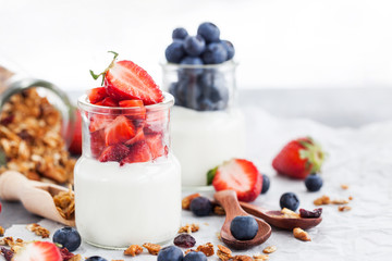 Delicious plain yogurt with fresh blueberry and strawberry in a glass jars