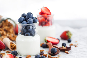 Delicious plain yogurt with fresh blueberry and strawberry in a glass jars