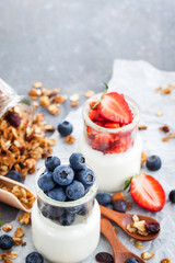 Delicious plain yogurt with fresh blueberry and strawberry in a glass jars