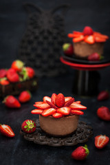 Obraz na płótnie Canvas Mini chocolate cheesecake dessert decorated with fresh strawberries