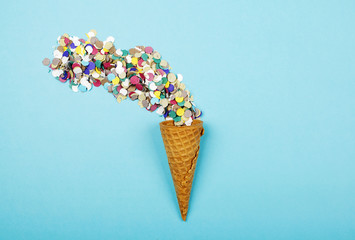 Iced cone with serpentine on blue background. Conceptual, party. Horizontal shoot