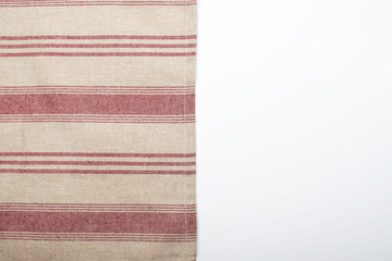 Background of striped kitchen tablecloth over white background. Copy space.