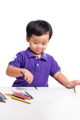 Portrait of cheerful boy drawing with colorful pencils