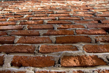 Closeup of weathered red brick wall.
