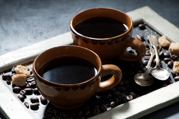 two cups of black coffee and sugar on the blackboard, closeup