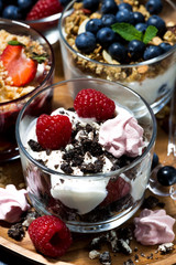 various desserts with berries and cream, vertical closeup