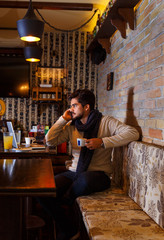 Young man sitting in a cafe and working on his laptop.