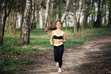 Running woman. Female runner jogging during outdoor workout in a park.