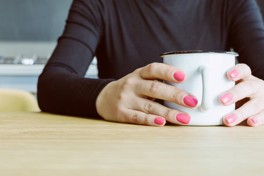 woman hands holding cup of hot drink
