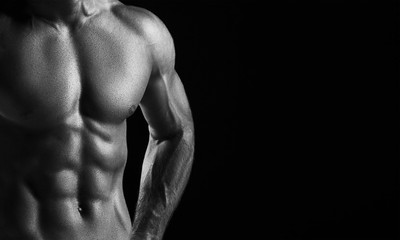 Fototapeta na wymiar The torso of attractive male body builder on black background.