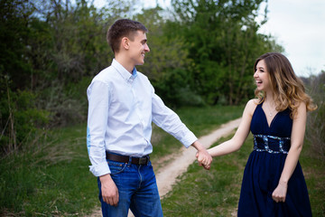 Couple in love walking in the woods holding hands and laughing