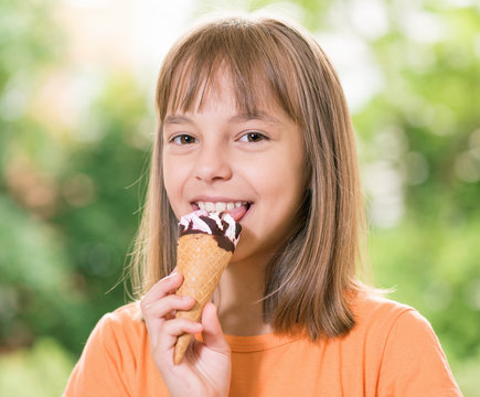 Outdoor portrait of happy little girl 10-11 year old with ice cream cone