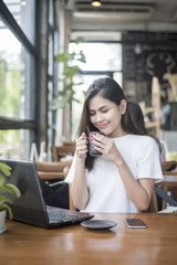 Obraz premium Beautiful business girl working with tablet , smartphone and drinking coffee in coffee shop