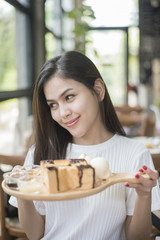 Beautiful girl holding dessert in coffee shop