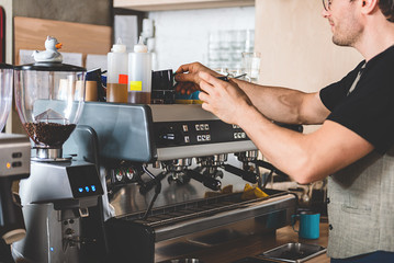 Happy barista making mug of beverage