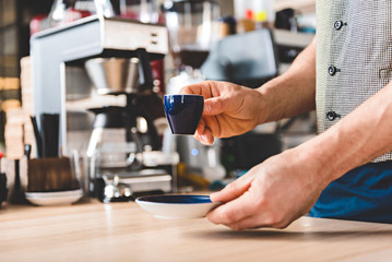 Barista arms putting mug of beverage