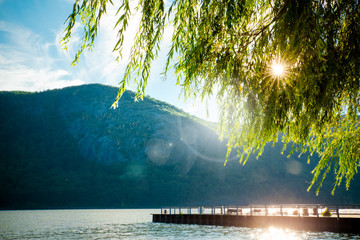 River, mountains and dock with sun shining through the trees from Cold Spring NY