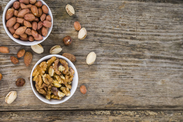 Nuts in a plate on a  wooden table.