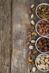 Nuts in a plate on a  wooden table.