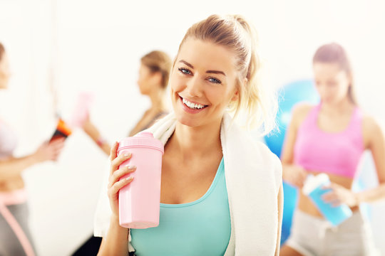 Portrait of beautiful mature woman with bottle smiling in health club