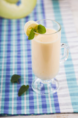 Smoothie with melon on a wooden table.