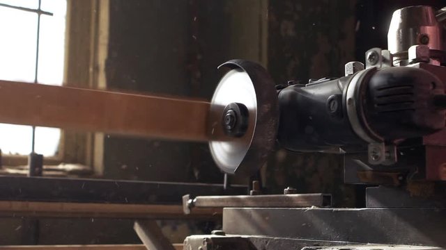 Angle grinder working on wood product in slowmotion