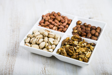 Nuts in a plate on a  wooden table.