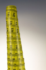 Rolled old yellow tape measure 


