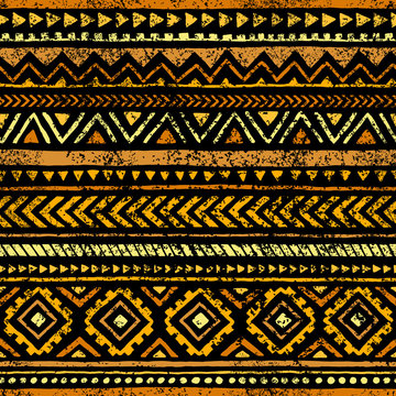 Golden seamless print. Ethnic and tribal motifs. Yellow geometric elements on a black background. Grunge texture. Vintage print.