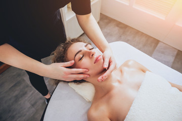 Obraz na płótnie Canvas Beautiful woman in spa salon getting facial massage