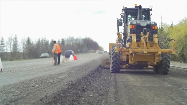 A road crew repairs the road out of the city.
