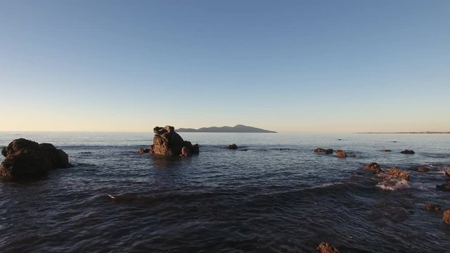 Aerial view of rocky coastline and Kapiti Island in the distance