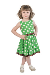 A little pretty child, in a smart green dress, stands cross-legged and her hands on her waist.