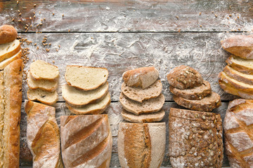 Bread bakery background. Brown and white wheat grain loaves composition on rustic wood