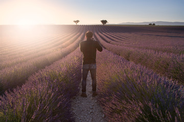 Man photographing a field of lavender in Provence at sunset