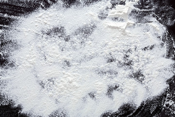 Baking concept on black background, sprinkled flour with copy space