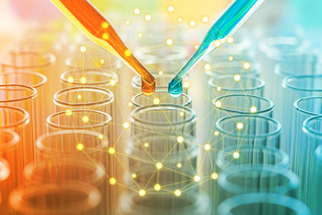 science pipette with a drop of substance over laboratory test tubes