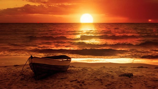 Lonely boat and beautiful sunset at the sea.