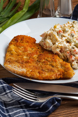 Fried pork chop in breadcrumbs, served with vegetable salad.