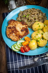 Fried pork chop, baked potatoes and fried young cabbage.